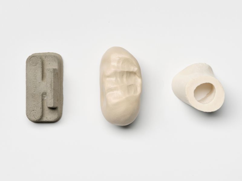 *The building body II*, 2024, Concrete casts, unfired clay sculptures, lacquered, and pieces of bone. 
Photo: Tobias Hübel